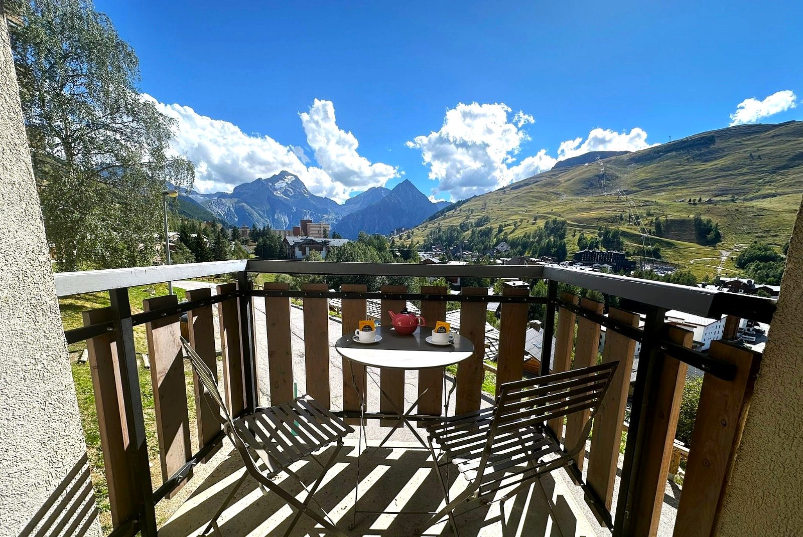 Balcon avec table pour deux et vue sur les sommets et les pistes des Deux Alpes